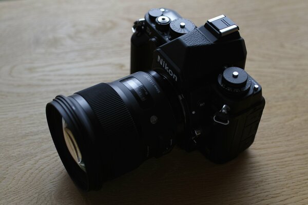 A black Nikon camera on a wooden table