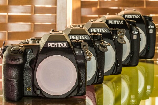 Линейка pentax фотокамер на столе