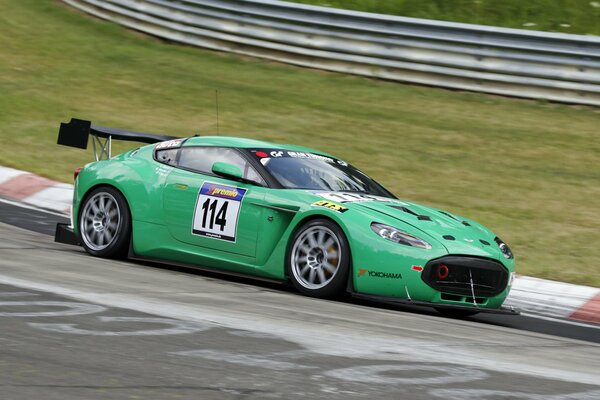 Green car rides on a racing track