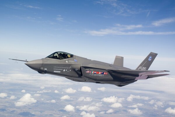 Fliegender Kampfjet im blauen Himmel mit Wolken