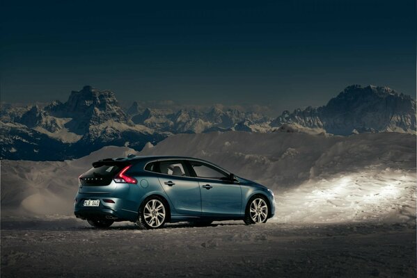 Ein Volvo-Fahrzeug inmitten von Bergen und Schnee in der Dämmerung