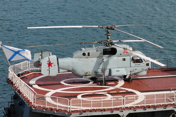 A military helicopter on the runway of an aircraft carrier