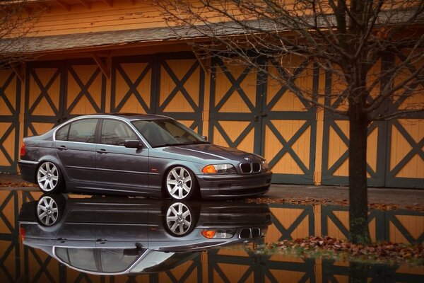 BMW grau mit Reflexion in einer Pfütze