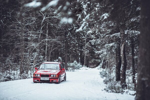 Ein altes deutsches Auto fährt durch einen verschneiten Wald