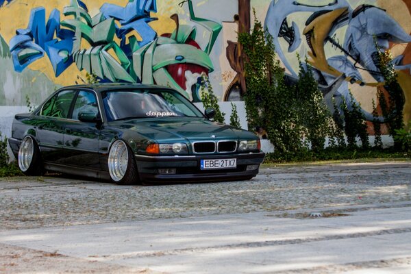 Oscuro clásico BMW E38 con fondo de graffiti