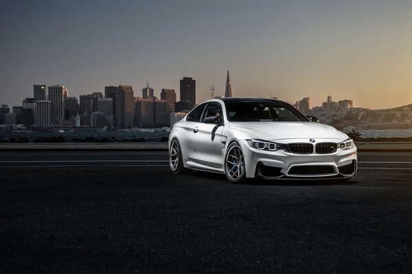 White bmw on the background of a city sunset