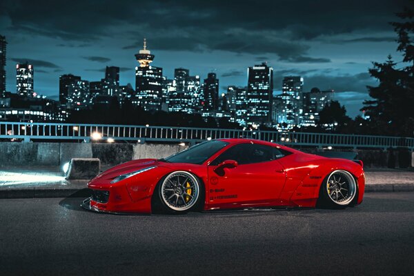 Ferrari rojo en el fondo de las luces de la ciudad nocturna