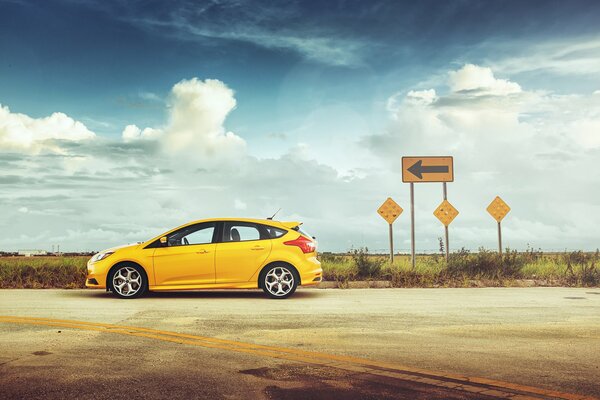 The yellow car is on the highway