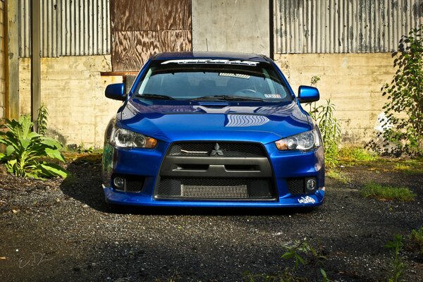 Blue Mitsubishi lancer in the yard of the house