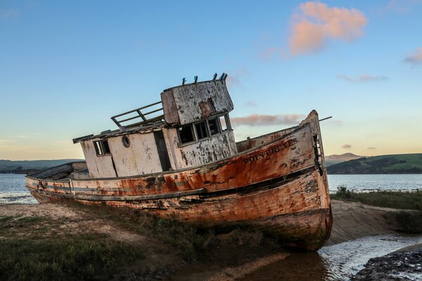 Un barco antiguo se encuentra en la costa de California