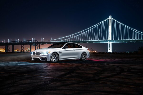 BMW blanc dans la nuit sur fond de pont blanc