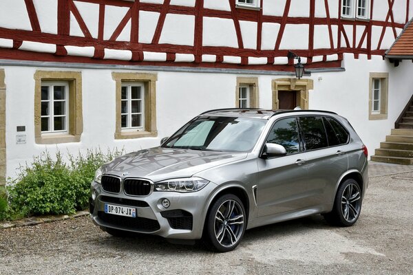 BMW X5 , 2015 года на фоне дома металлик