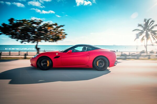 Ferrari rojo mate contra el fondo de la carretera y el cielo