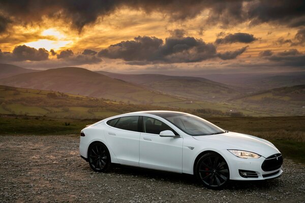 Tesla bianca al tramonto in montagna