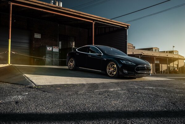 Black Tesla Model S driving out of the garage