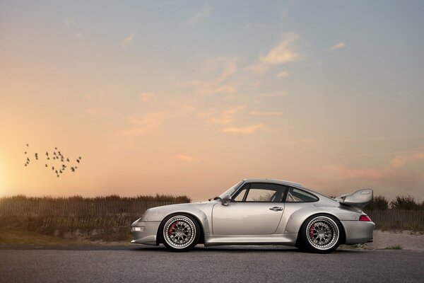 Porsche argent sur fond de ciel coucher de soleil