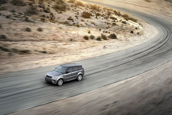 A gray SUV rushes down the road