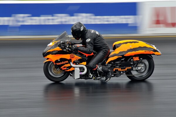 Moto naranja en movimiento en la pista