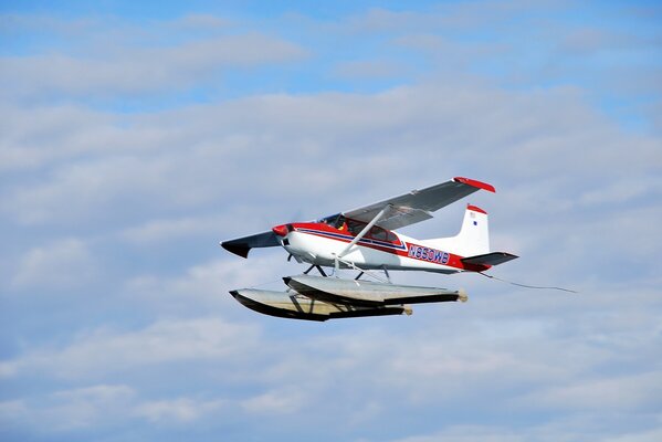 Das einmotorige Flugzeug cessna a 185f schwebt im blauen Himmel