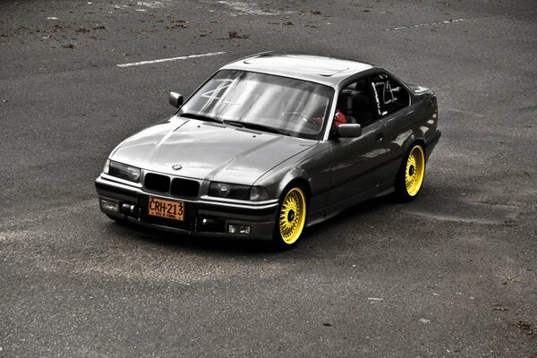 BMW noir avec Jantes jaunes sur la route