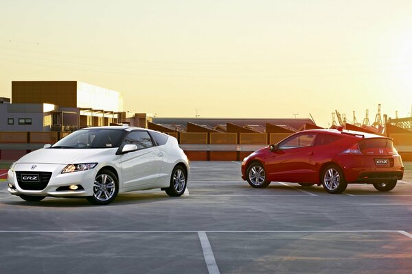 Honda blanc et rouge sur fond de coucher de soleil urbain