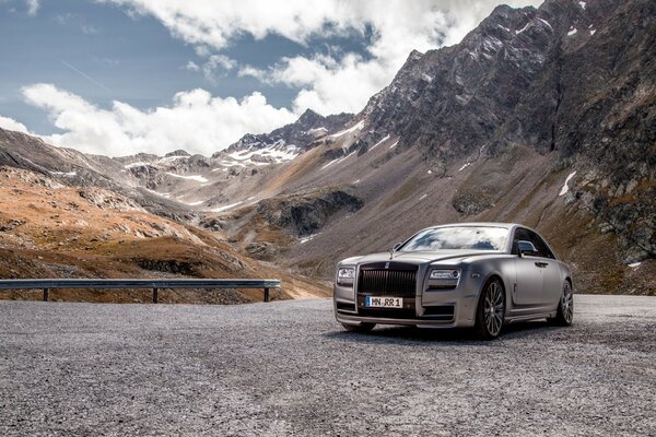 Voiture argentée de luxe sur fond de montagnes