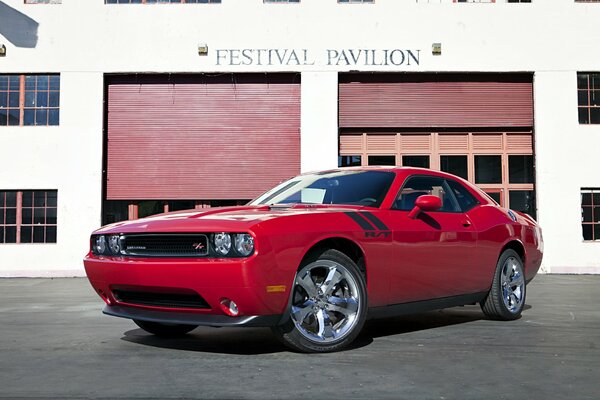 Voiture rouge dodge challenger près du bâtiment