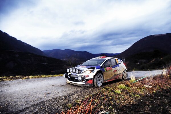 Course de rallye Ford fiesta sur fond de montagnes