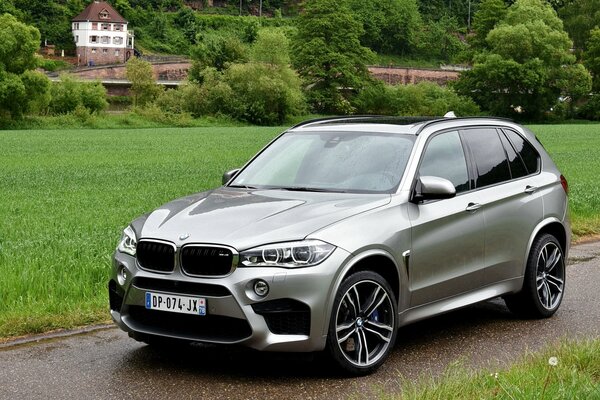 BMW x5m auf dem Hintergrund der Häuser