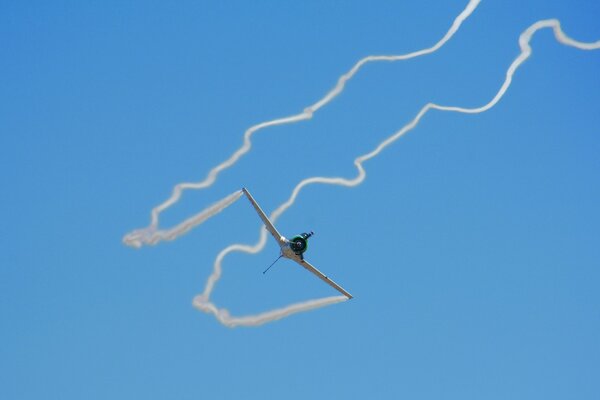 L aereo lascia tracce intricate bianche nel cielo blu