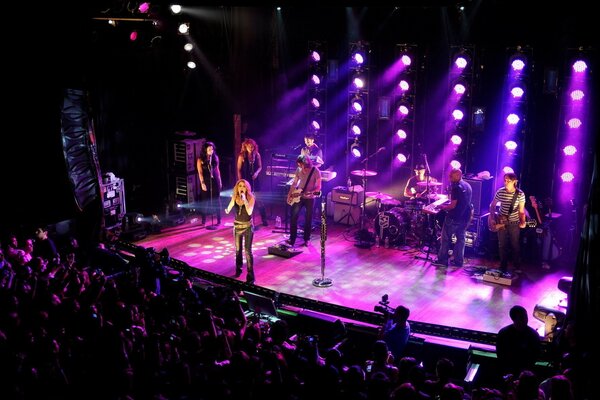 Performing on stage under pink spotlights