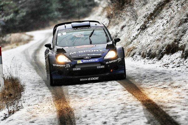 Coche negro frente en carretera cubierta de nieve