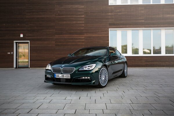 Bmw, alpina parked near the entrance to the brown building