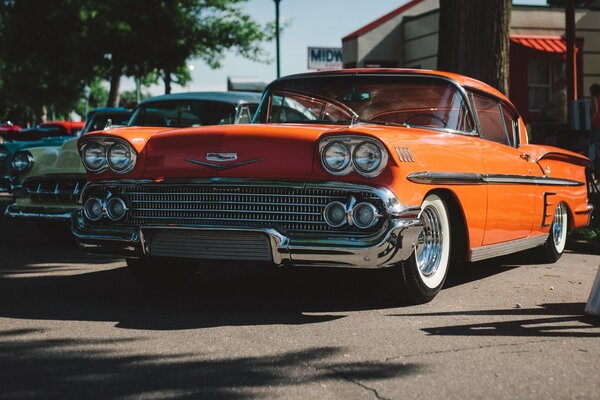 Cool retro orange car is parked on the street