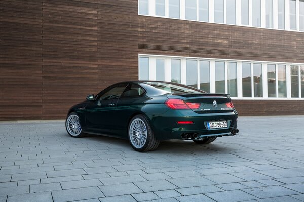 Black BMW car on the background of a brown building