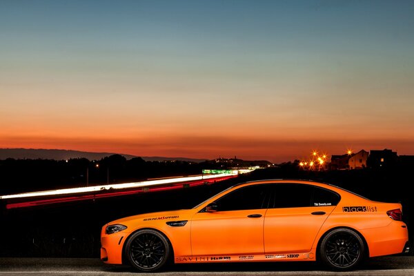 Coche naranja en el fondo de la ciudad nocturna