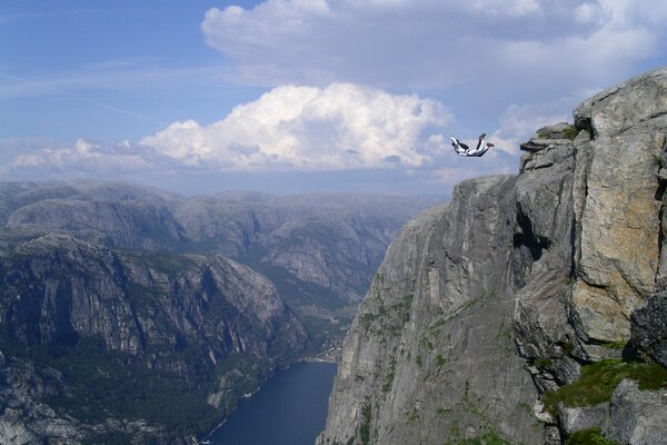 In a mountainous area above the water, the flight of an airplane