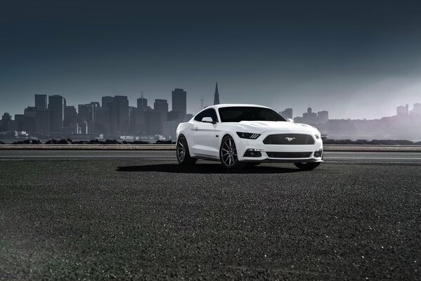 Ford Mustang blanco en el fondo de la ciudad