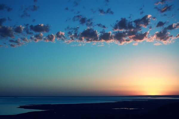 Tramonto in riva al mare con tempo calmo