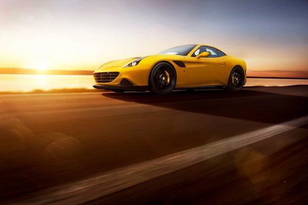 Ferrari supercar jaune au coucher du soleil