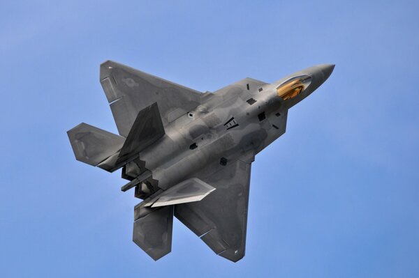 A fighter jet flies up against a clear sky