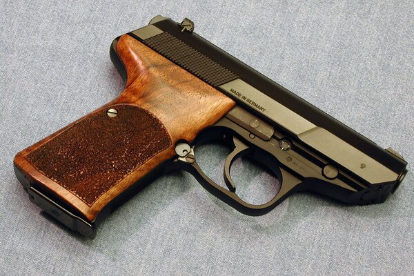 A pistol with a wooden handle is lying on the table