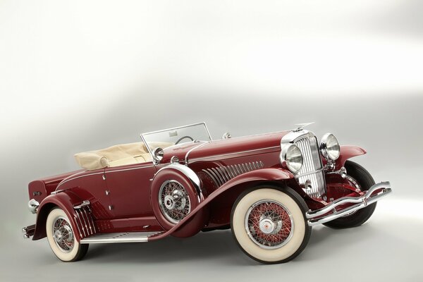 Beautiful burgundy convertible car on a gray background