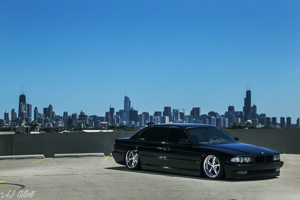 Une BMW E38 noire sur fond de Chicago aux Etats-Unis