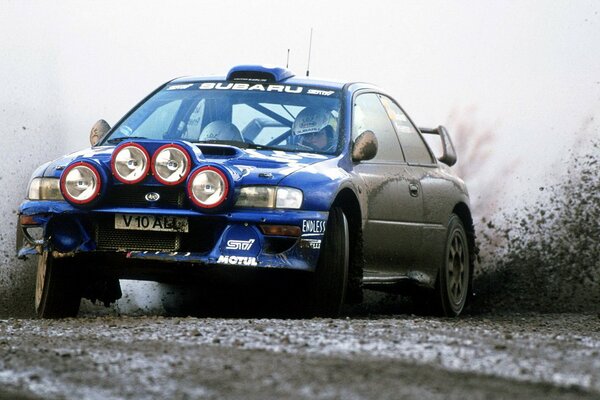 A blue car on a dirty road