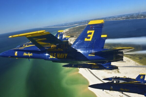 Blue military planes flying over the sea