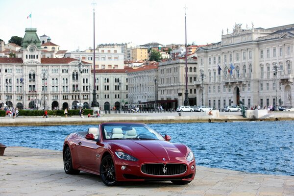 Roter Maserati auf dem Hintergrund einer schönen Stadt