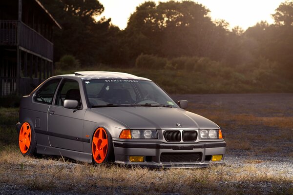 Grauer BMW mit Tuning bei Sonnenuntergang