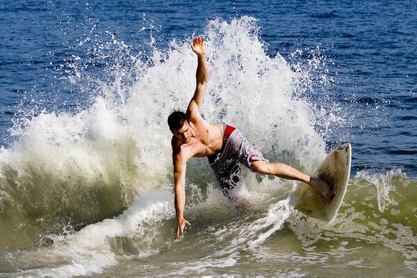 Chico guapo en una tabla de surf