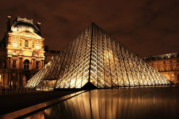 Beleuchtetes Museum in Form einer Pyramide in der Nacht